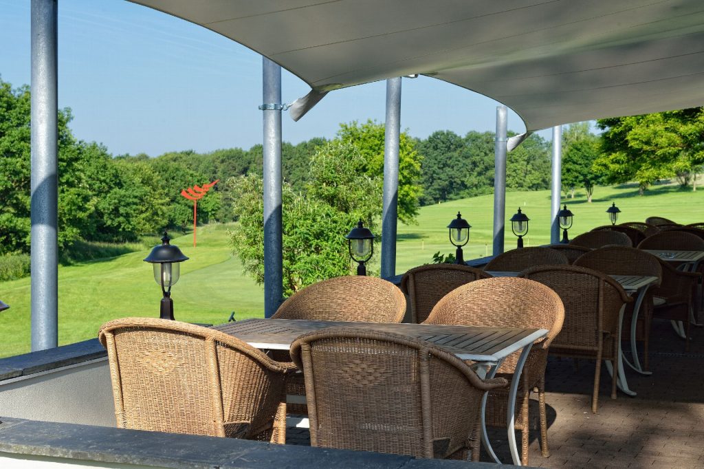 Clubhaus des Golf Course Bonn – St. Augustin mit Wegweisern zur Driving Range