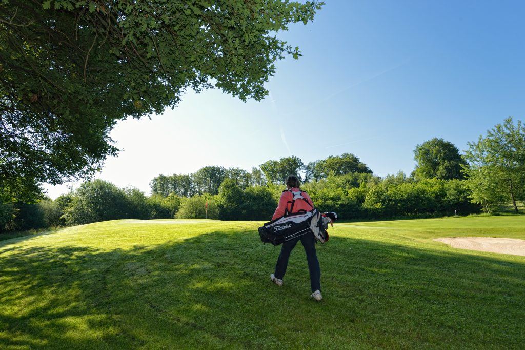 Golferin auf dem Weg zum nächsten Abschlag